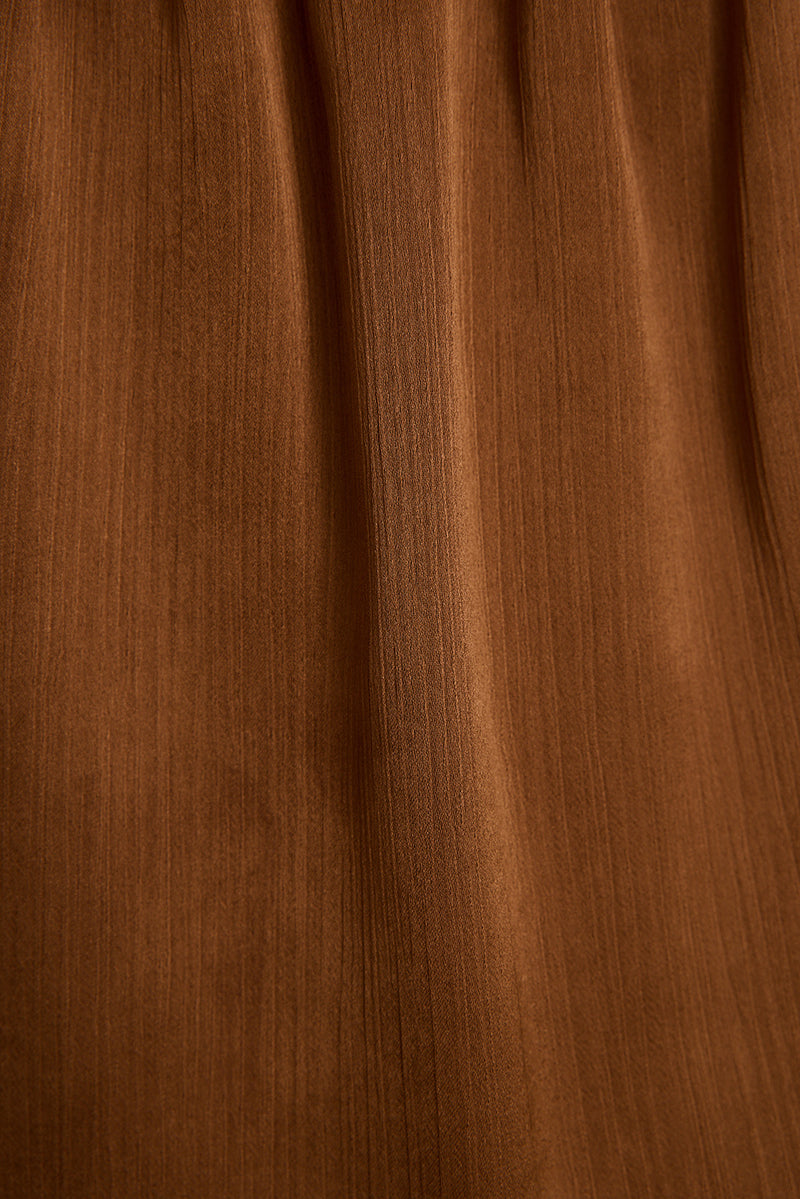 Close-up of the mocha satin halter top fabric showing its soft sheen and flowing drape.