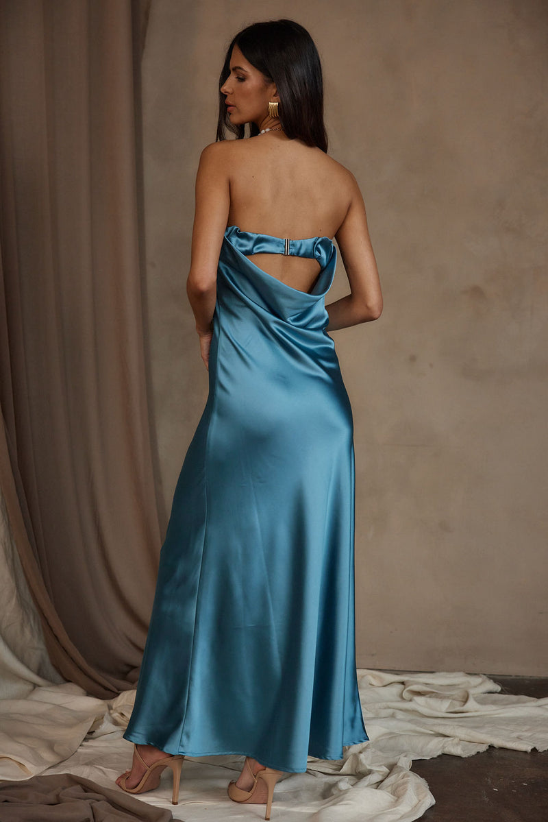 Back view of blue satin strapless maxi dress with cutout detail and nude heels.