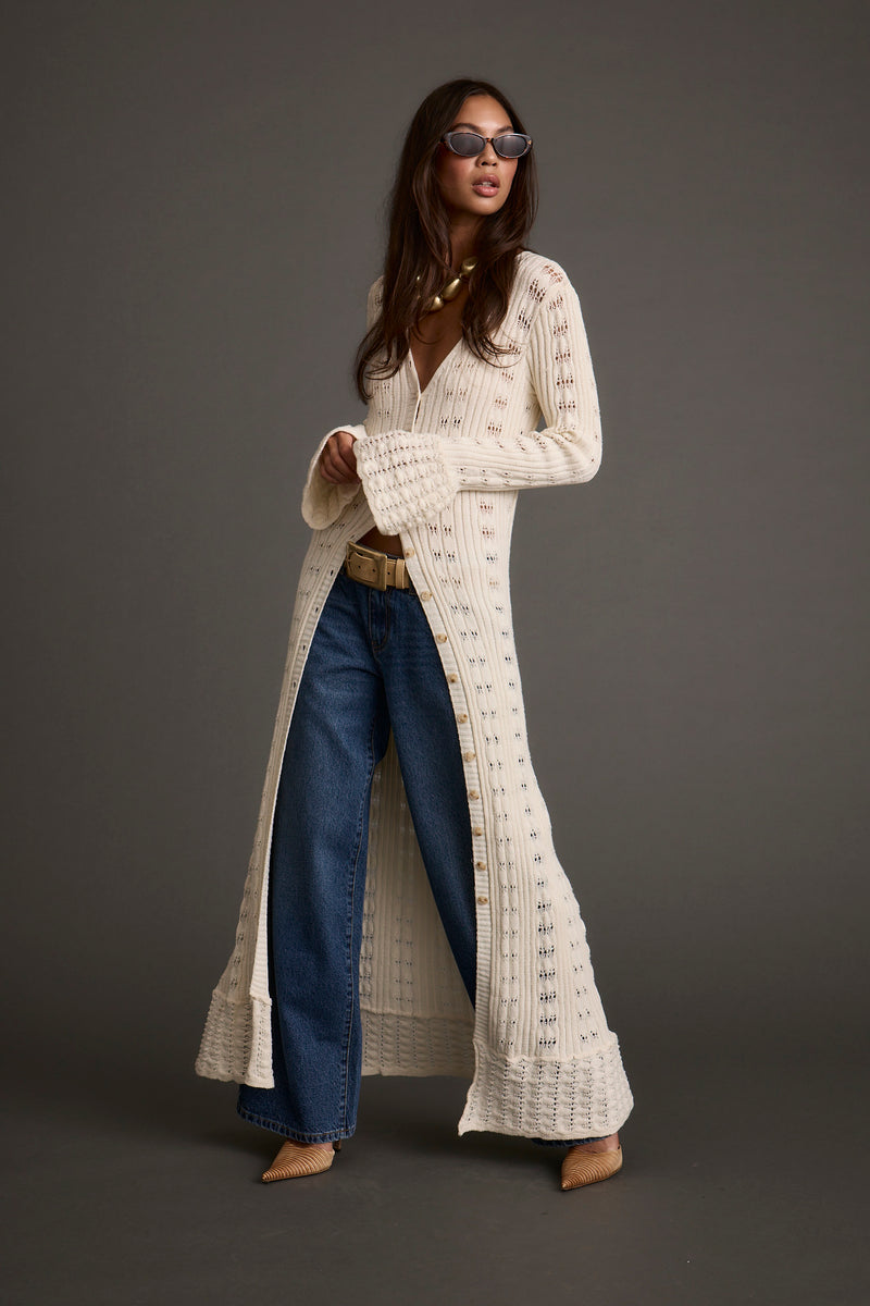 Lifestyle shot of the cream top styled for day-to-night versatility.