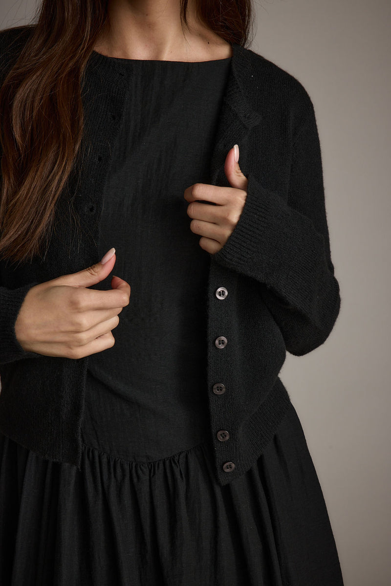 Full-length view of the black trousers showing the drape and movement.