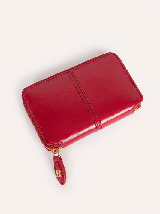 Close view of the Ristretto red aged leather wallet with golden zipper closure.