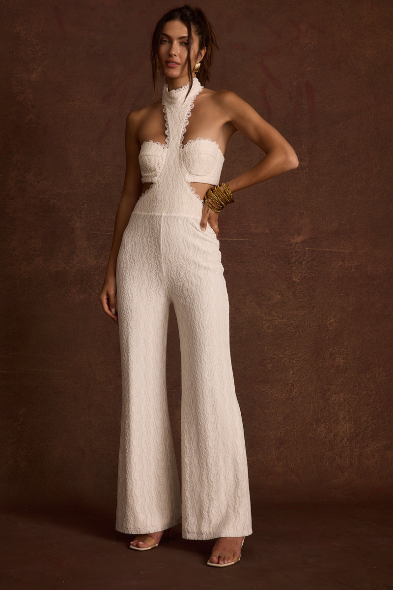 Back view of the white lace jumpsuit showing the silhouette and fit.