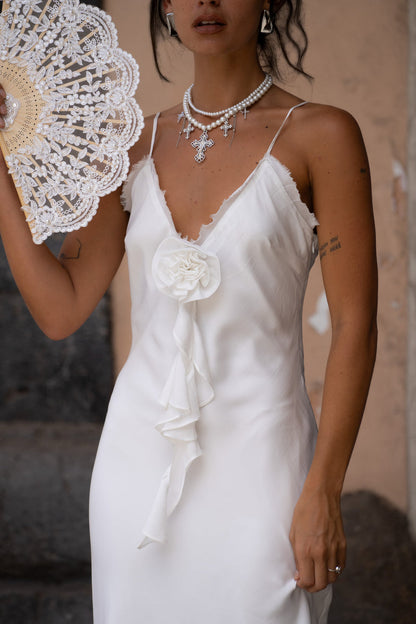 White maxi dress with elegant accents, a white rosette dress essential.
