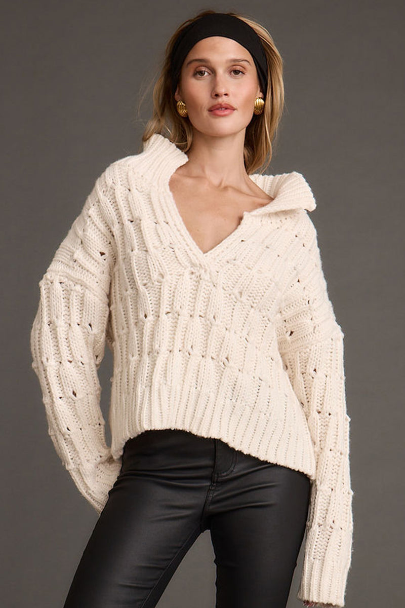 Cream sweater with refined detailing and a flattering silhouette.