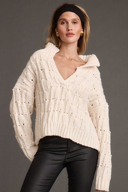 Cream sweater with refined detailing and a flattering silhouette.