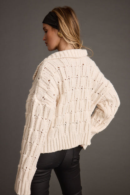 Back view of the cream sweater showing the silhouette and fit.