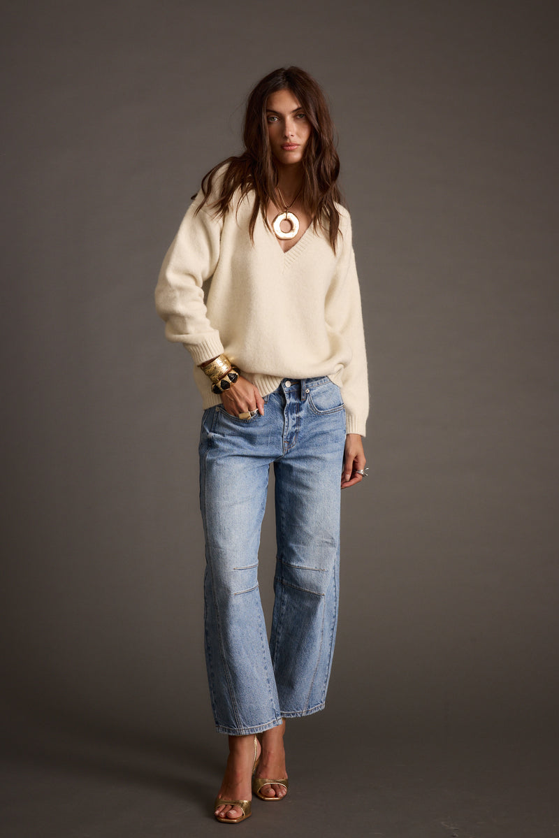 Back view of the ivory sweater showing the silhouette and fit.