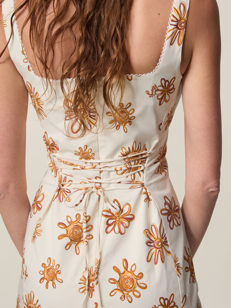 Close up of the back view of the Elny sun print dress tied at the dress.