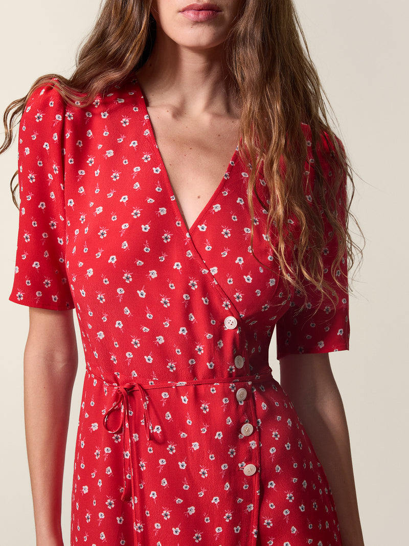 Zoom in on the white floral print and pearl buttons of the red Gabin wrap dress.