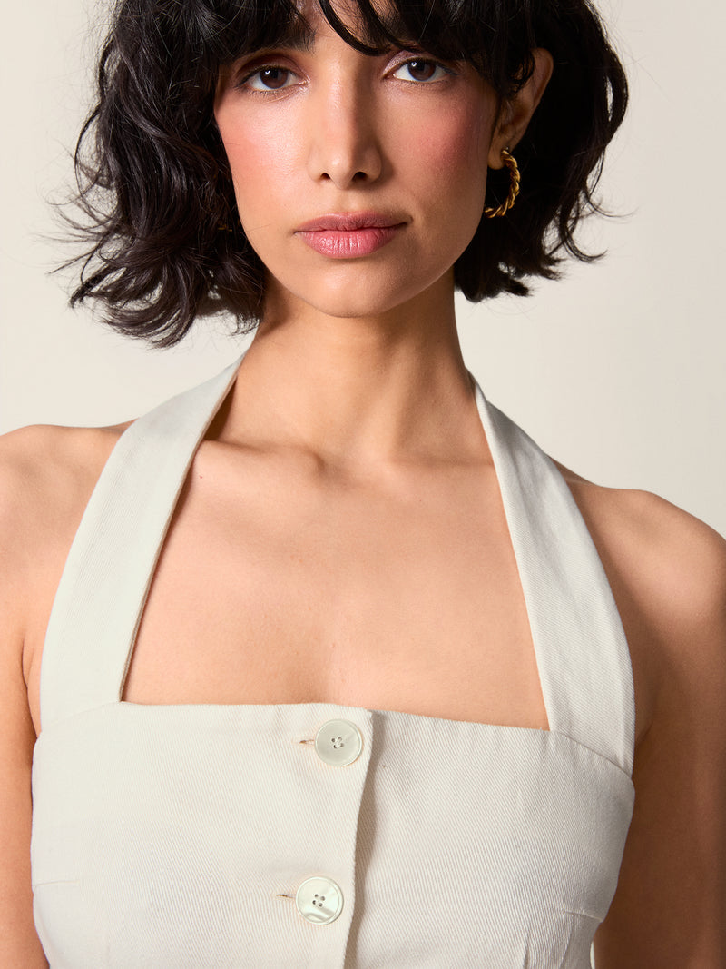 Detail on the décolleté of the Griselda dress, buttoned at the front and strapped behind the neck.