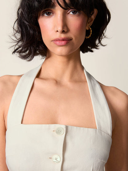 Detail on the décolleté of the Griselda dress, buttoned at the front and strapped behind the neck.