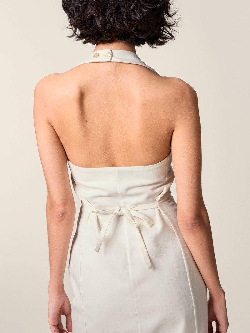 Back view of the white Griselda dress, tied at the waist and strapped at the neck.