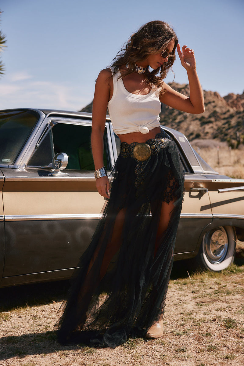 Full-length view of the black maxi skirt showing the drape and movement.