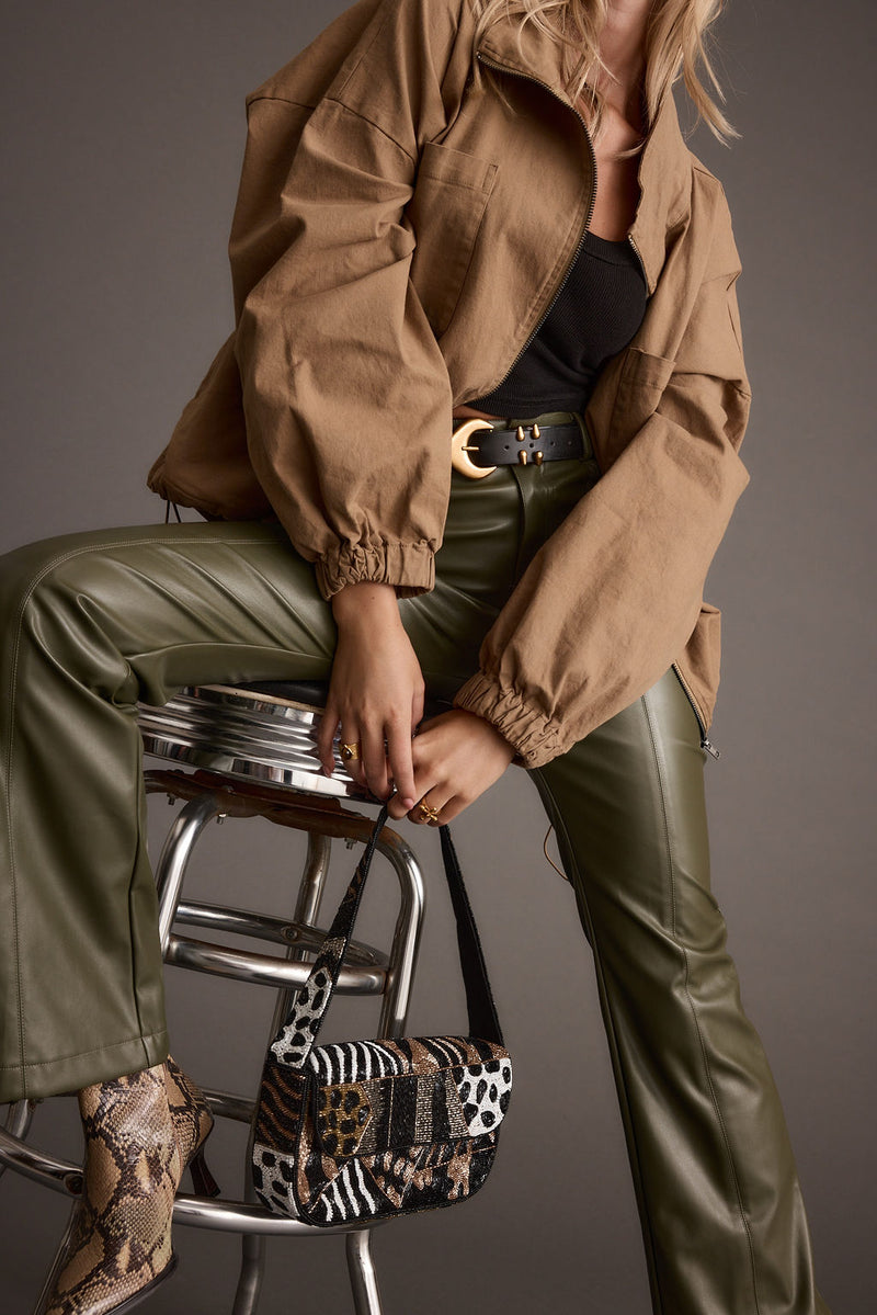 Close-up of the Ryland Olive Vegan Leather Flare Pants showcasing the vegan leather texture and craftsmanship.