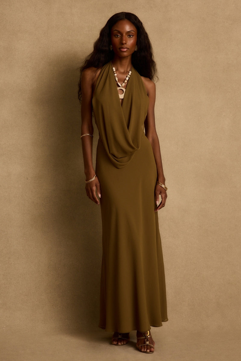 Olive cowl-neck halter maxi dress styled with beaded necklace and gold sandals.