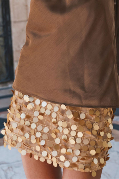 Gold paillette sequin mini skirt paired with a brown satin top, detail view.