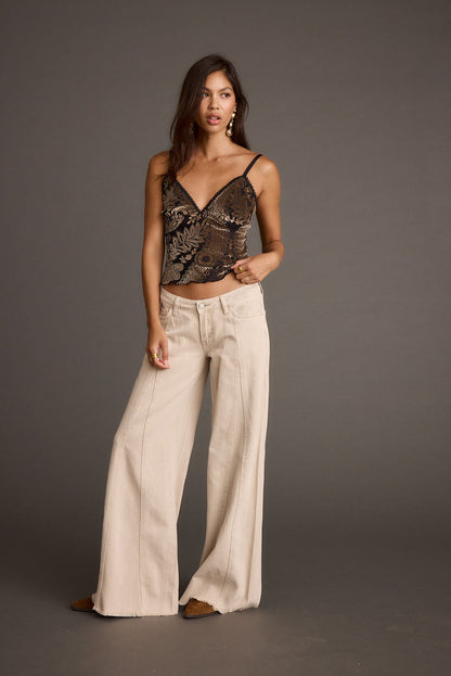Full-length view of the beige jeans showing the drape and movement.