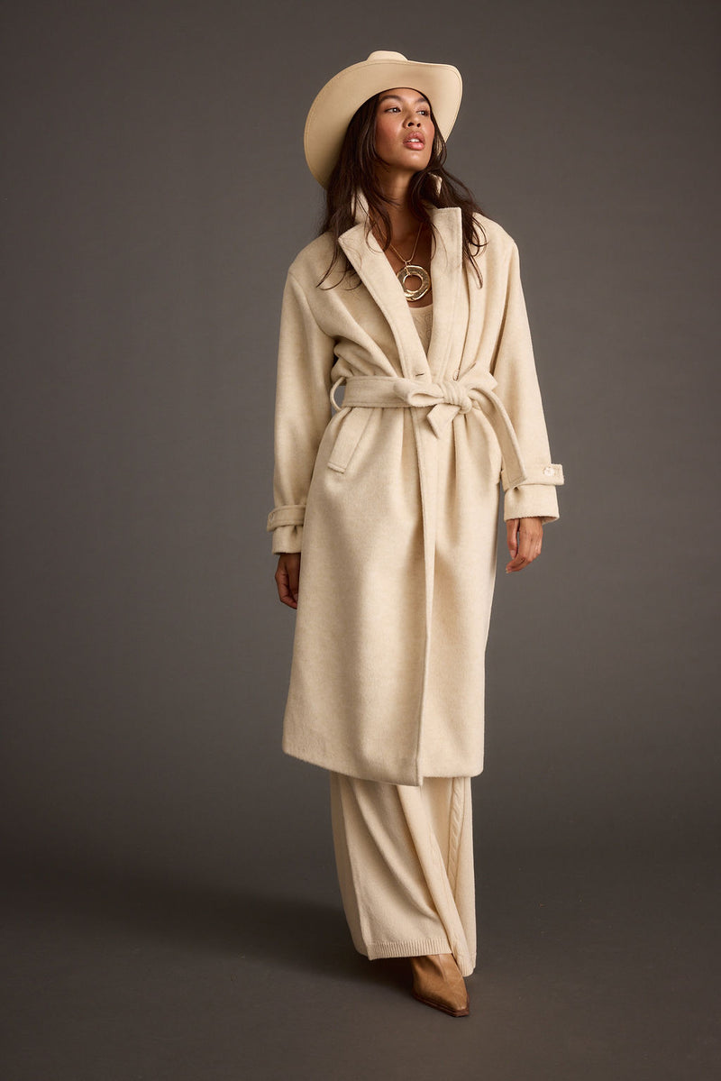 Close-up of the Sinclair Ivory Belted Coat showcasing the fabric texture and design details.