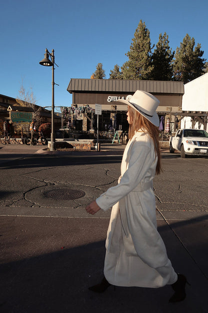 Full-length view of the ivory jacket showing the drape and movement.