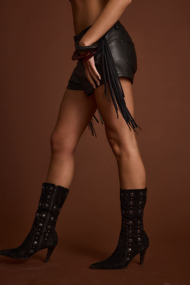 Lifestyle shot of the black shorts styled for day-to-night versatility.