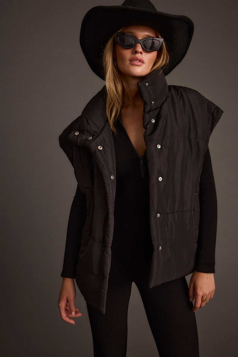 Black vest with refined detailing and a flattering silhouette.