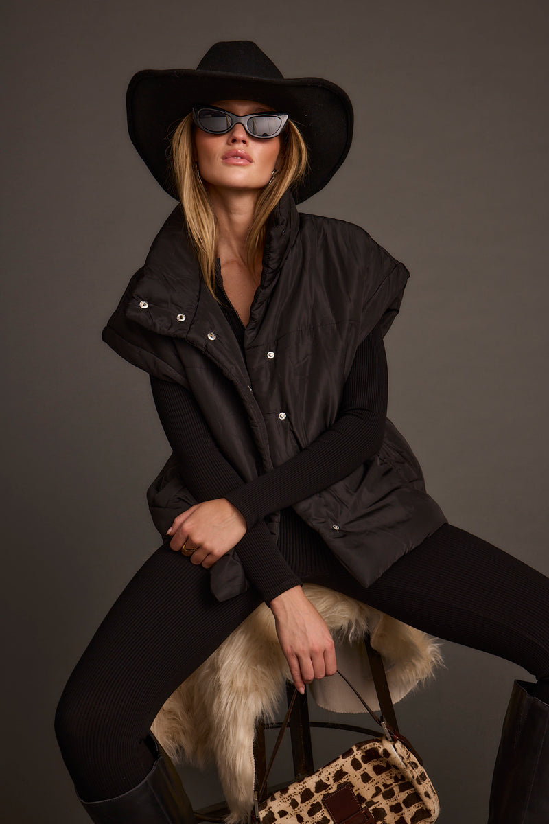 Lifestyle shot of the black vest styled for day-to-night versatility.