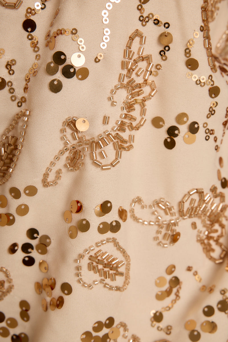 Full-length view of the ivory halter top showing the drape and movement.
