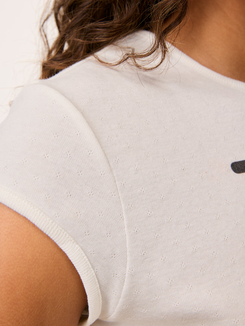 Close-up of the sleeve on the Fergus white printed T-shirt worn by a model