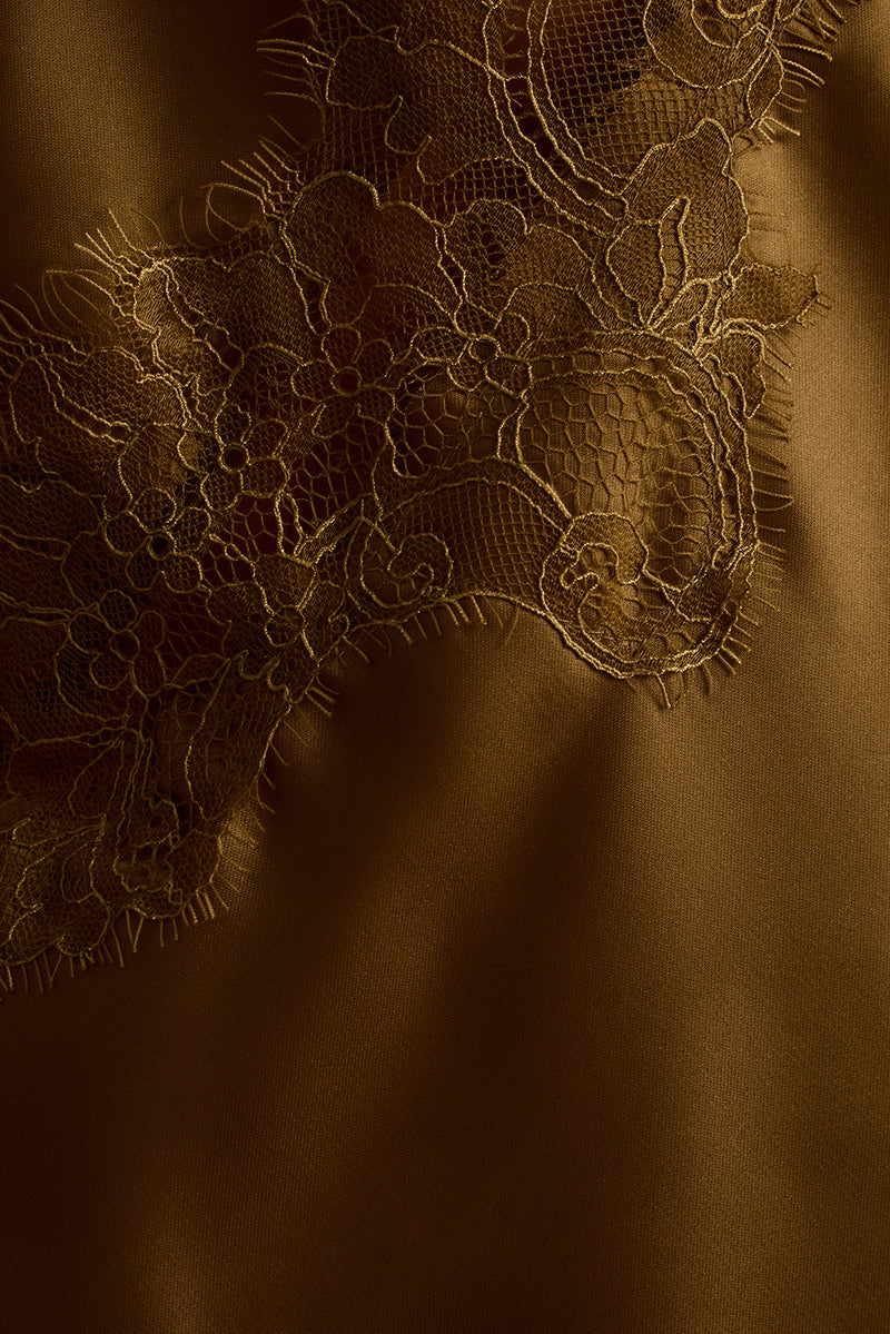 Close-up of olive satin tank with floral lace trim along the neckline.