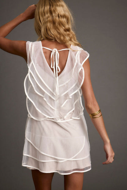 Back view of the white tulle mini dress showing the silhouette and fit.