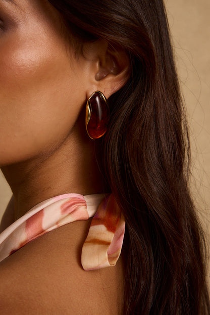 Model wearing the 12th Tribe Veda Amber Stone Earrings with warm amber tones. Featuring a natural stone drop style. Pair with elevated looks for weddings, bachelorette parties, and vacation outings.
