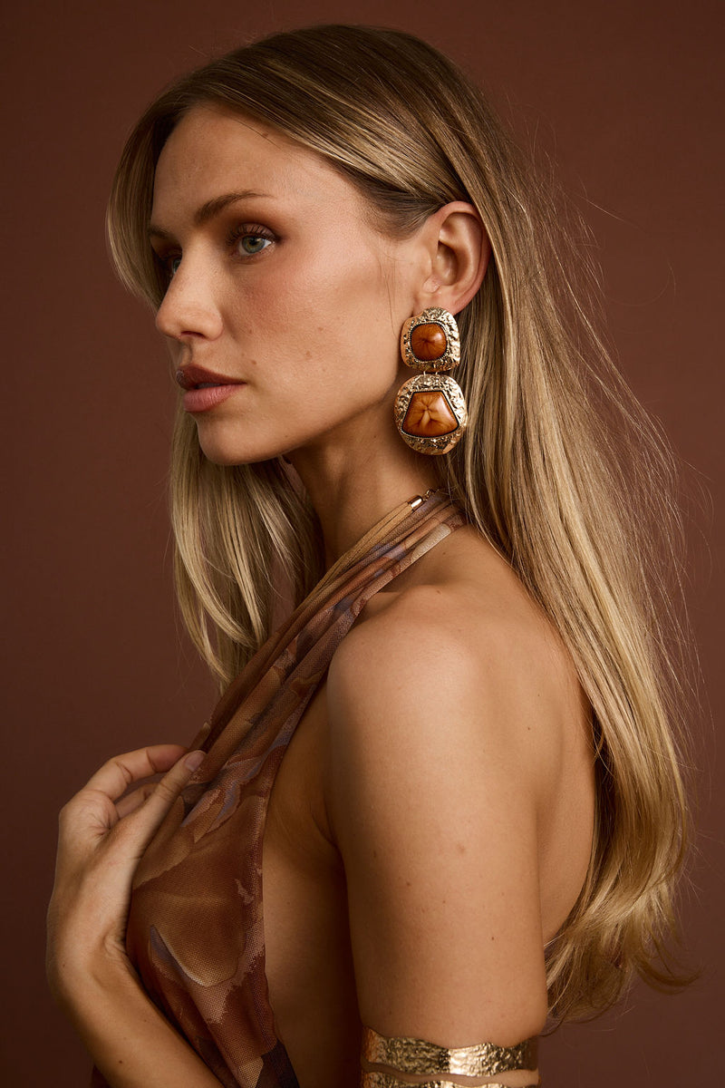 Close-up of the Wild Ember Gold Statement Earrings showcasing the metalwork and pendant detail.