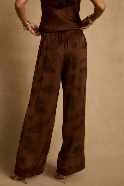 Back view of espresso brown floral satin pants with elastic waist and wide legs.